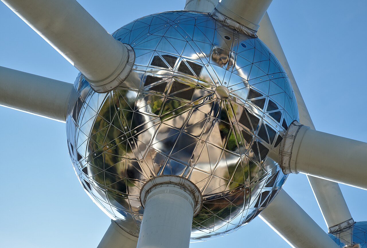 Een bol van het Atomium met weerspiegeling van het park